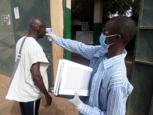 A health worker screens for fever